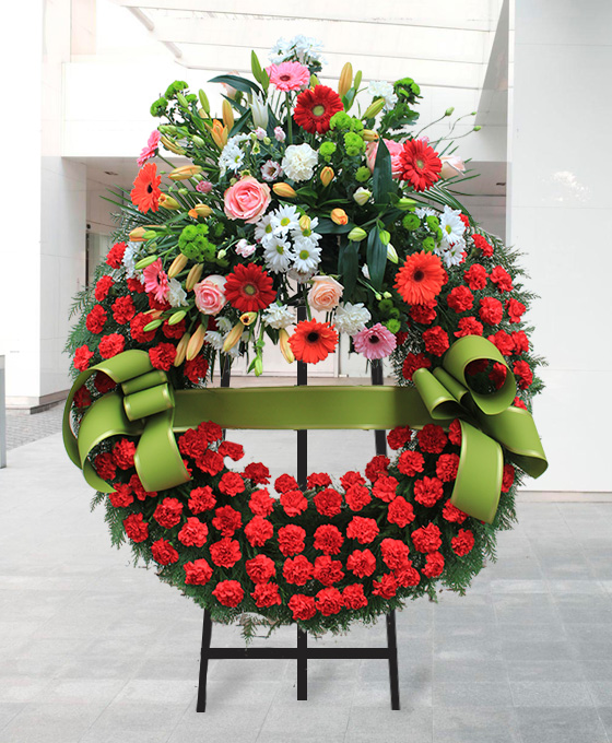 Corona funeraria con flores rojas